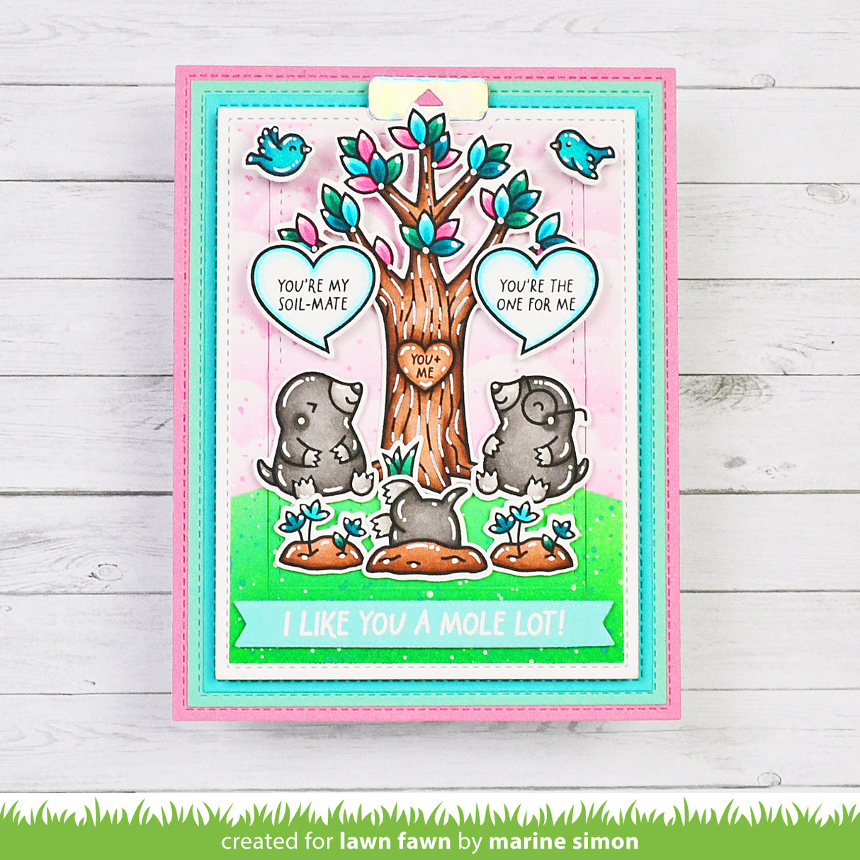 Card with cartoon moles and tree, featuring text 'You're my soul mate' and 'I like you a mole lot!' on a wooden background.