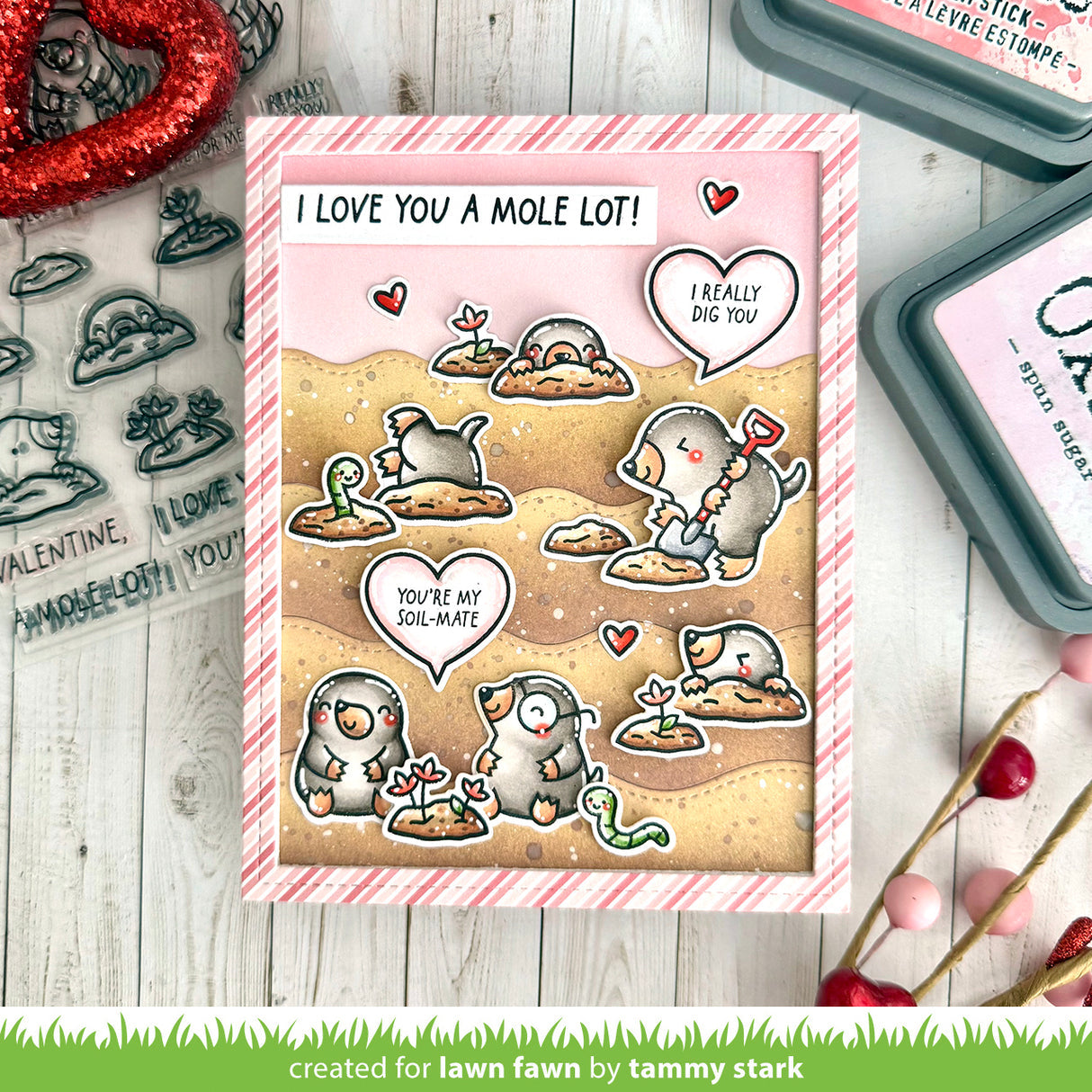 Valentine's Day card with mole design and text, surrounded by stamping tools on a wooden surface.