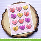 Card with heart-shaped die pattern on a wooden surface