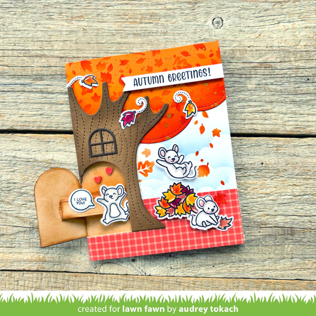Autumn-themed card with tree design and 'Autumn Greetings!' text on a wooden surface.