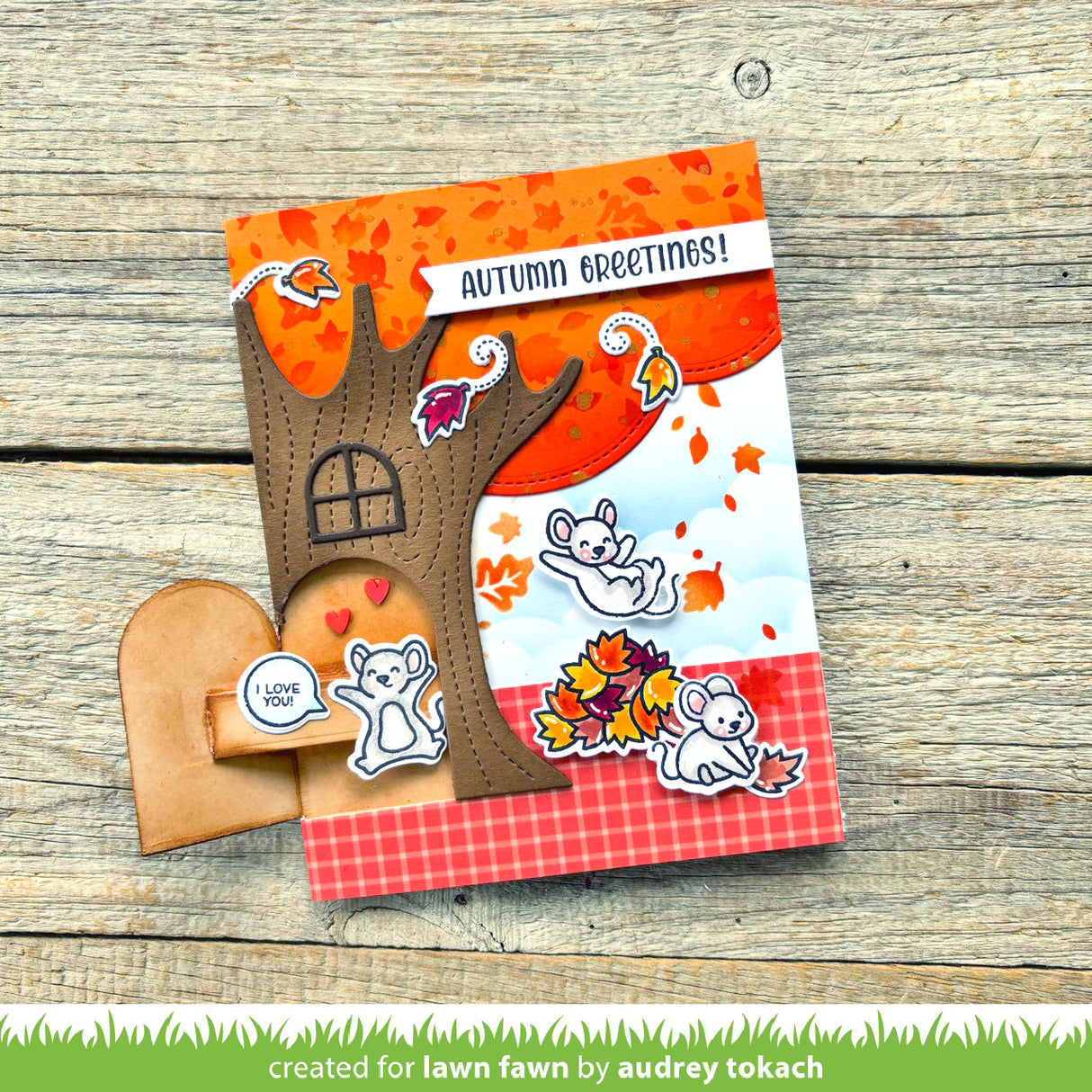 Autumn-themed card with tree design and 'Autumn Greetings!' text on a wooden surface.