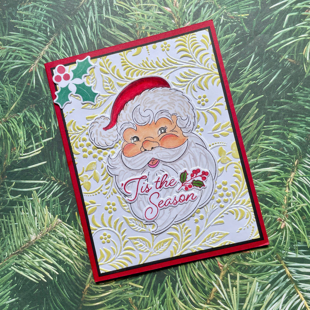 Christmas card with Santa Claus face and 'Tis the Season' text on a green leaf background